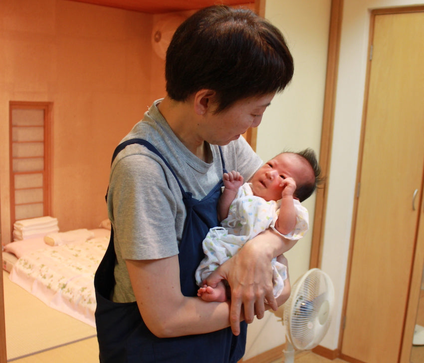 赤ちゃんを抱っこする助産師